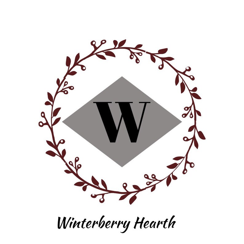 May include: A logo featuring a dark burgundy wreath encircling a gray diamond with a bold black "W". The text "Winterberry Hearth" is written in a cursive font below the wreath.