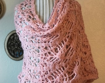 May include: A light pink, open-weave shawl draped over a mannequin. The shawl is made of a soft, textured yarn, and features a delicate, lacy pattern. The design is a cowl neck style, with a long, flowing scarf. The shawl is a beautiful accessory.