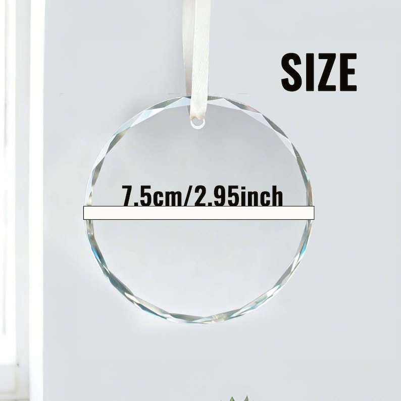 May include: A clear, faceted crystal ornament with a white ribbon. The circular ornament has a diameter of 7.5cm (2.95 inches). The word "SIZE" is printed in bold black letters.