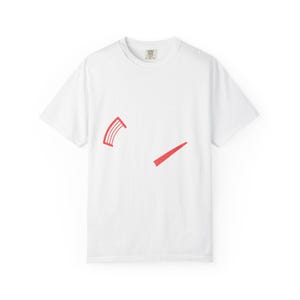 Op de afbeelding: Wit T-shirt met een ronde hals en korte mouwen. Het shirt heeft twee rode abstracte vormen op de voorkant: een gebogen, gesegmenteerde vorm en een diagonale lijn. Het shirt is gemaakt van een zacht materiaal, waarschijnlijk katoen.