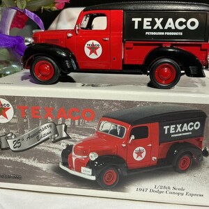 May include: A red and black Texaco 1947 Dodge Canopy Express toy truck. The truck has the Texaco logo on the doors and the side of the truck bed. The box reads "25th Anniversary Edition".
