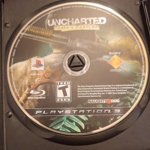 May include: A circular PlayStation 3 Blu-ray disc for the video game Uncharted: Drake's Fortune. The disc features a character holding a shotgun, the Naughty Dog logo, an ESRB Teen rating, and Sony Computer Entertainment branding.