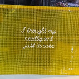 May include: A yellow mesh zippered pouch with the text "I brought my needlepoint just in case" in white script. The pouch is rectangular and appears to be made of a durable, see-through material, suitable for storing craft supplies.