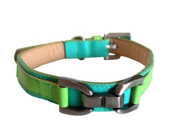 May include: A green and turquoise leather dog collar with a silver buckle. The collar is made of two layers of leather, with the top layer being a lighter green color.