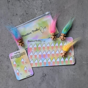 May include: A set of Positive Trolls Only items, including a clear zip pouch, cards, and troll figurines. The cards display a grid of troll illustrations and the text "Positive Trolls Only". The trolls have colourful hair in pink, blue, and yellow.