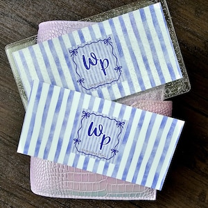 May include: Two rectangular cards with a light purple and white vertical striped pattern. Each card features a central blue logo with the letters Wp and the text Wednesday Plans enclosed in a decorative frame with small bow accents at the corners.
