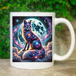 Könnte beinhalten: Weiße Keramiktasse mit einer farbenfrohen Illustration eines Fuchses, der auf einer Wolke vor einem Vollmond sitzt. Der Fuchs ist mit einem galaktischen Muster aus Sternen und Wirbeln in Blau, Rosa und Lila bedeckt.