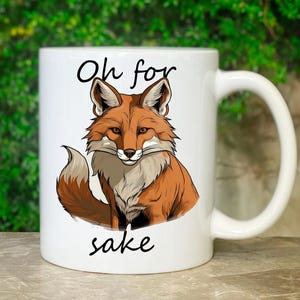 May include: White ceramic coffee mug with a red fox illustration and the text "Oh for sake" printed on it.