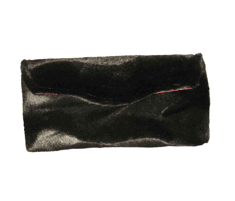 May include: A black faux fur clutch with a red stitch detail.