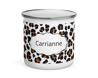 May include: White enamel mug with a leopard print pattern in black and brown spots. The mug features the name "Carrianne" in a white, stylized text box. The mug has a silver rim.