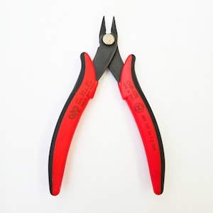 May include: A pair of red and black CHP-170 wire cutters. The handles are red with black grips, and the cutting blades are black. The text "CHP-170 MADE IN ITALY" is printed on one handle, and "MAX CUT Cu 1.3 mm" is printed on the other.