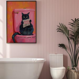 May include: A black cat sitting on a pink toilet with a newspaper that reads "Wash Your Paw" in a bathroom setting with a white bathtub and a white toilet.
