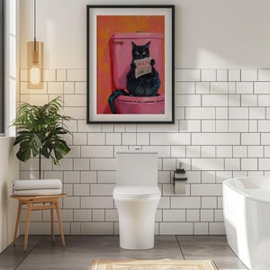 May include: A black cat sitting on a pink toilet with a sign that says "Wash Your Paws" in a bathroom with white tile walls. The cat is holding a newspaper in its paws.