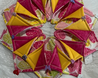 Centro de mesa rosa y amarillo con detalles de mariposas y corazones.
