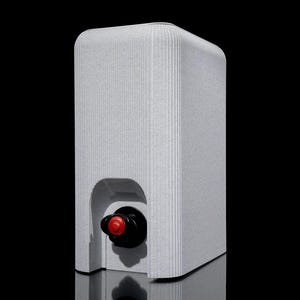 May include: A light gray wine box with a textured, vertically ribbed surface. The box has a rounded top and a rectangular shape. A black wine spout with a red cap is visible in the front. The box is reflected on a dark surface.