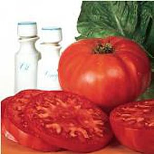 May include: Three red ripe tomatoes, one whole and two sliced in half, with a white background and two clear glass bottles.