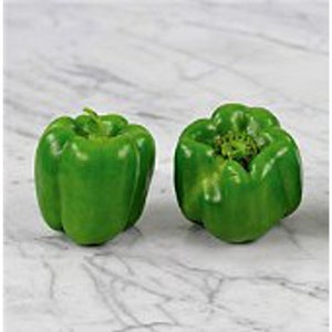 May include: Two green bell peppers on a white marble surface. The peppers are whole and have a glossy finish.