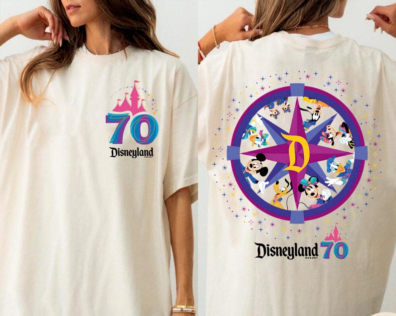 May include: Off-white t-shirt with a Disneyland 70th anniversary design. The front has a castle graphic, the number 70, and the Disneyland logo. The back features a compass design with various Disney characters.