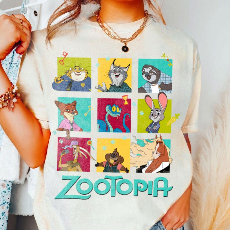 Puede incluir: Camiseta color crema con una cuadr&iacute;cula de personajes de Zootopia en cuadrados coloridos. El logotipo de Zootopia est&aacute; impreso en turquesa debajo. La camiseta tiene un corte holgado y mangas cortas.
