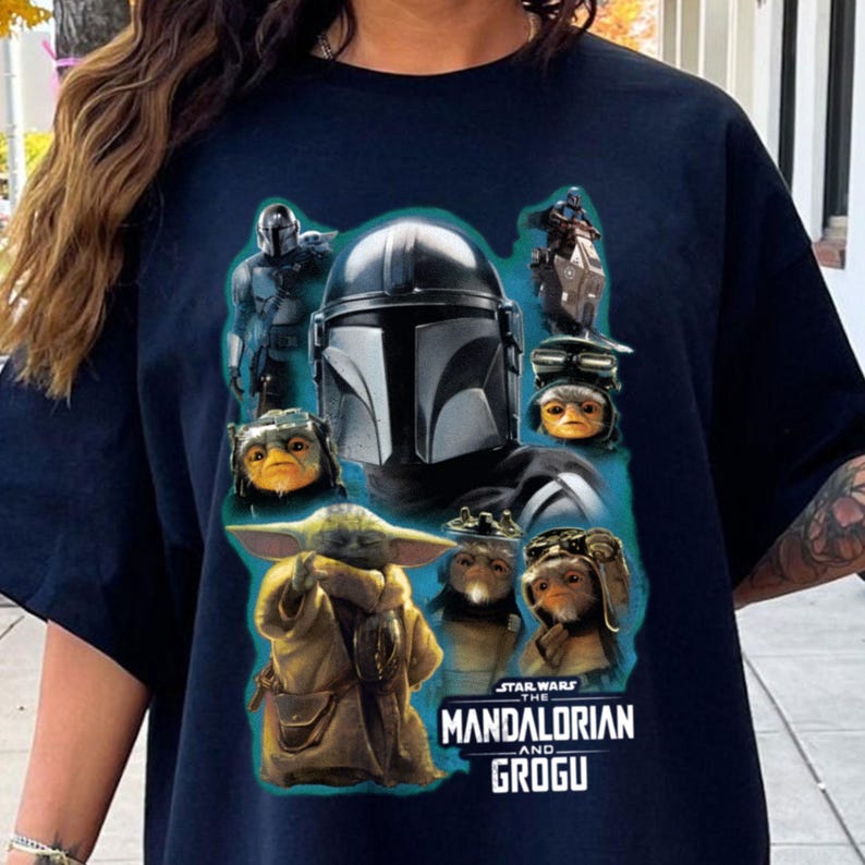 Puede incluir: Camiseta azul marino con personajes de la serie The Mandalorian. El dise&ntilde;o incluye el casco del Mandaloriano, Grogu y otros personajes. El texto "STAR WARS THE MANDALORIAN AND GROGU" est&aacute; impreso en la parte inferior.