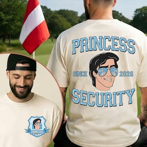 May include: Cream-colored t-shirt with the words "PRINCESS SECURITY" in light blue. The shirt features a cartoon illustration of a man wearing sunglasses. The shirt has the text "SINCE 2026".