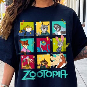 Puede incluir: Camiseta azul marino con un gr&aacute;fico colorido de personajes de la pel&iacute;cula animada Zootopia. El dise&ntilde;o incluye im&aacute;genes de un guepardo, un lince, un perezoso, un zorro, una serpiente, un conejo, un rat&oacute;n, un perro y un caballo. La palabra "Zootopia" est&aacute; impresa en verde.