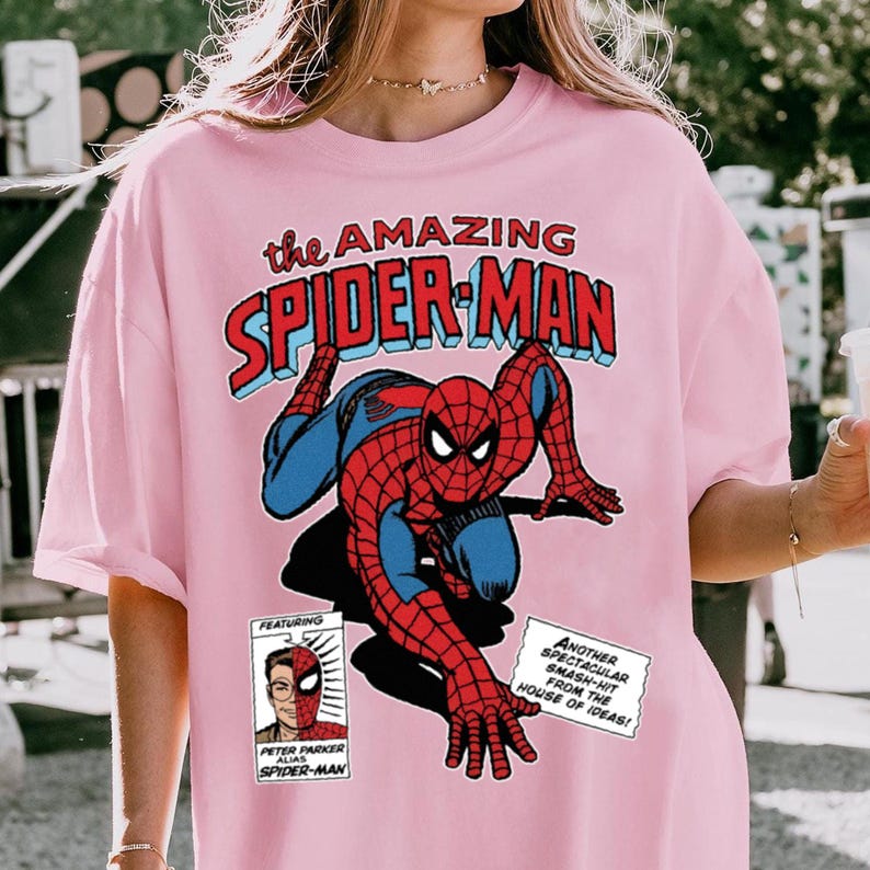 Może przedstawiać: Jasnor&oacute;żowa koszulka z komiksową grafiką Spider-Mana. Projekt przedstawia Spider-Mana w akcji, z napisem "the AMAZING SPIDER-MAN". Zawiera panel z Peterem Parkerem. Swobodny top dla fan&oacute;w serii komiks&oacute;w.