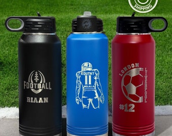May include: Three stainless steel water bottles with black lids and carrying loops. The black bottle features a football graphic and the name Riaan. The blue bottle shows a football player with the name Koutny. The red bottle displays a soccer ball.