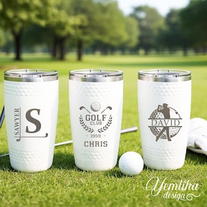 May include: Three white stainless steel tumblers with dimpled textures resembling golf balls. The first features the name Sawyer and the letter S. The second displays a golf club emblem, 1959, and the name Chris. The third shows a golfer silhouette and David.