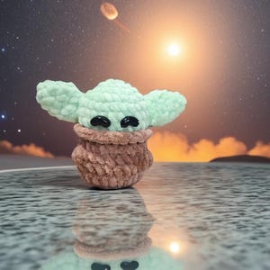May include: A handmade crochet figure of a character with large ears and black eyes. The figure is light green and brown, with a textured appearance. The background features a starry sky and a bright light source, creating a whimsical scene.