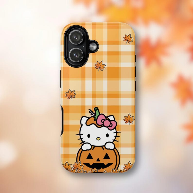 May include: A phone case with a Halloween theme. The case has a yellow and white plaid pattern with cartoon maple leaves. A cartoon cat with a pink bow is sitting on a carved pumpkin. The case has a camera cutout.