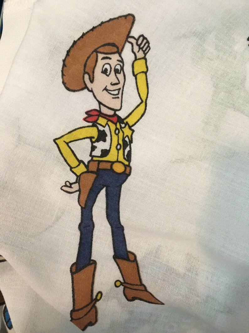 Op de afbeelding: Een cartoonillustratie van Woody uit Toy Story. Hij draagt ​​een bruine cowboyhoed, een geel shirt met een rode bandana, een bruine riem, een blauwe jeans en bruine cowboylaarzen. Hij glimlacht en geeft een duim omhoog.