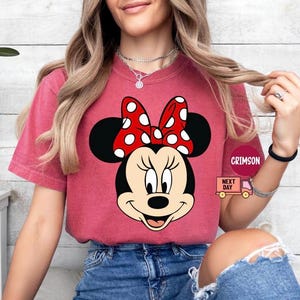 May include: A white ceramic mug with a black handle and the text "But First, Coffee" in a bold, black font. The mug is set against a blurred background, suggesting a cozy setting.