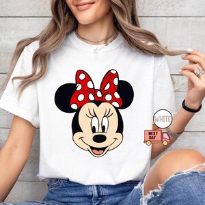 May include: A white ceramic mug with a black handle and the text "But First, Coffee" in a black, handwritten-style font. The mug is on a white surface.