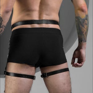 May include: Black leather leg straps with silver buckles. The straps are worn on the upper thighs and are adjustable.