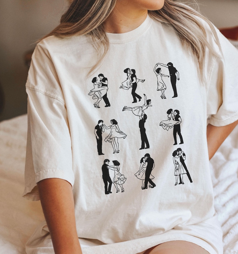 Puede incluir: Una camiseta blanca con un estampado gr&aacute;fico negro de una pareja bailando en varias poses. El gr&aacute;fico se repite nueve veces en la camiseta.