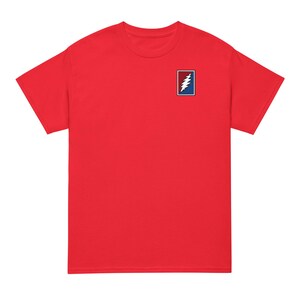 May include: A vibrant red t-shirt with a small rectangular emblem on the upper left chest. The emblem features a white lightning bolt design on a blue background, with a red border. The shirt is a plain colour.