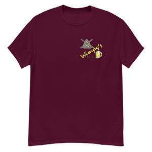 May include: Burgundy t-shirt featuring a yellow graphic of a pool table with balls and a beer mug. The text "Wimpy's" is written in yellow above the graphic.