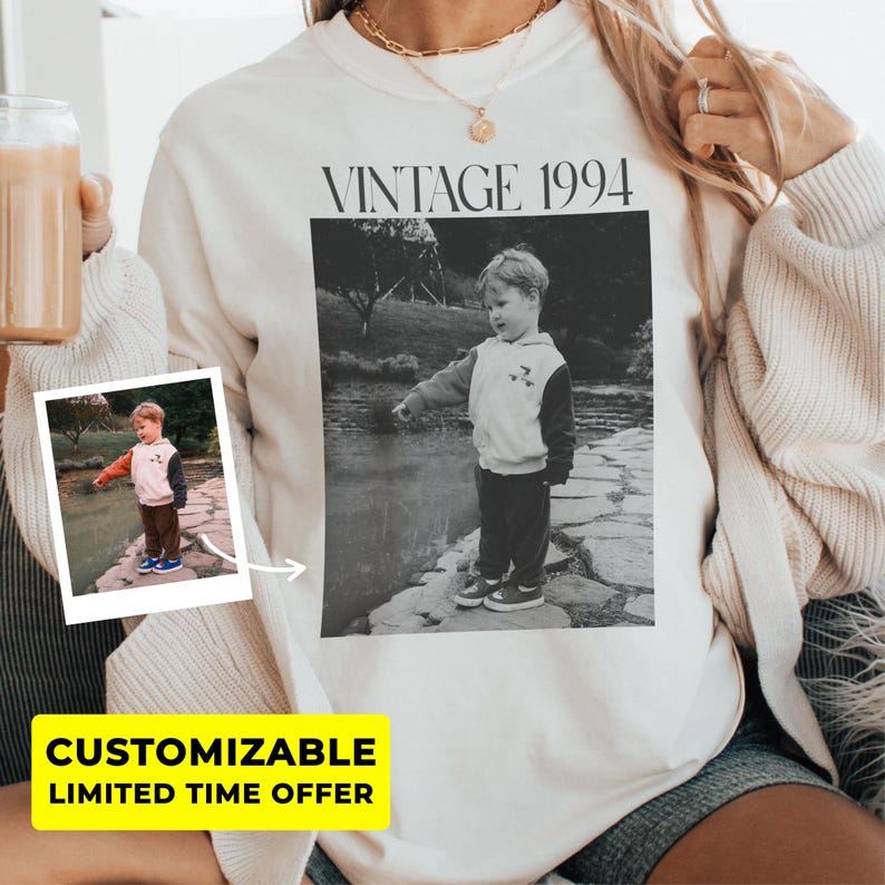 May include: Cream-colored sweatshirt with a black and white photo print of a child. The text "VINTAGE 1994" is above the photo. A smaller photo of the child is on the left. The words "CUSTOMIZABLE" and "LIMITED TIME OFFER" are in a yellow box.