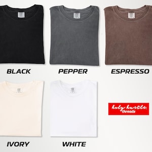 Puede incluir: Camisetas plegadas en negro, pimienta, espresso, marfil y blanco. Cada camiseta tiene cuello redondo y una peque&ntilde;a etiqueta. Los textos "BLACK", "PEPPER", "ESPRESSO", "IVORY" y "WHITE" est&aacute;n debajo.