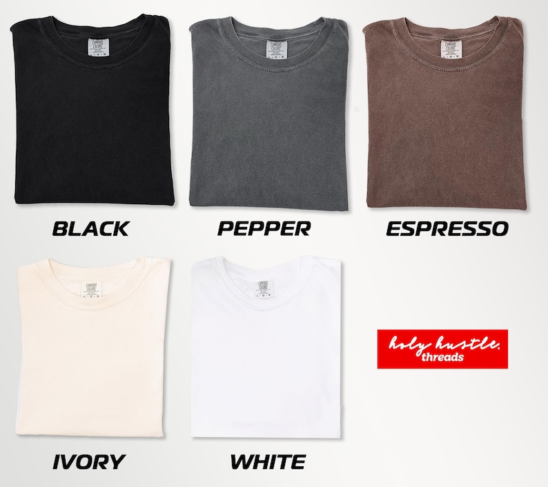 Puede incluir: Camisetas plegadas en negro, pimienta, espresso, marfil y blanco. Cada camiseta tiene cuello redondo y una peque&ntilde;a etiqueta. Los textos "BLACK", "PEPPER", "ESPRESSO", "IVORY" y "WHITE" est&aacute;n debajo.