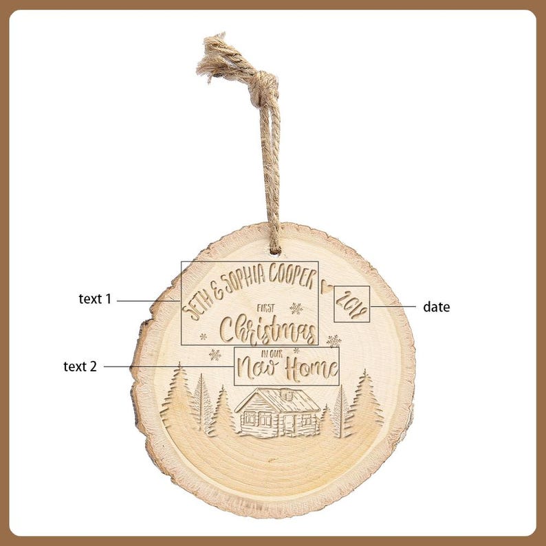 May include: A round, wooden Christmas ornament with a natural wood grain finish. The ornament features engraved text: "Seth & Sophia Cooper," "First Christmas," and "Now Home," along with the year "2019." A cabin and trees are also engraved.