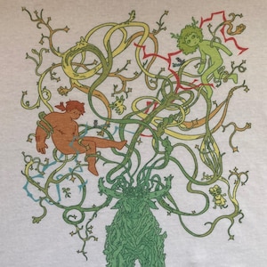May include: A light gray t-shirt featuring a whimsical illustration. The design includes a central green figure with a leafy appearance, surrounded by intertwining vines in yellow, green, and orange. Small figures are scattered throughout the design.