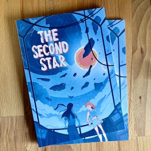 以下が含まれることがあります： 青と白のコミックの表紙で、太字の白い文字で「The Second Star」というタイトルが書かれています。2人の人物が、赤い星を背景に、青と白の惑星を見下ろすプラットフォームに立っています。