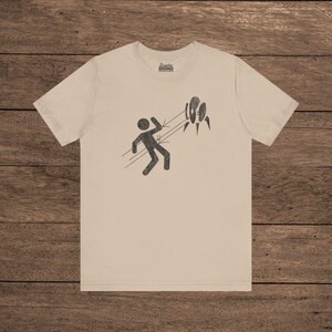 Tan Aperture Science Turret warning icon t-shirt on Bella+Canvas 3001, vintage distressed print, Portal and Portal 2 fan tee.