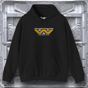 Puede incluir: Sudadera con capucha negra con un logotipo de Weyland-Yutani Corp amarillo y blanco y el texto "Building Better Worlds".