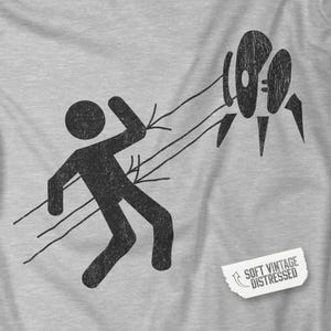 Closeup view of Heather Gray Aperture Science Turret warning icon t-shirt on Bella+Canvas 3001, vintage distressed print, Portal and Portal 2 fan tee.