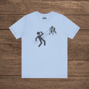 Light Blue Aperture Science Turret warning icon t-shirt on Bella+Canvas 3001, vintage distressed print, Portal and Portal 2 fan tee.