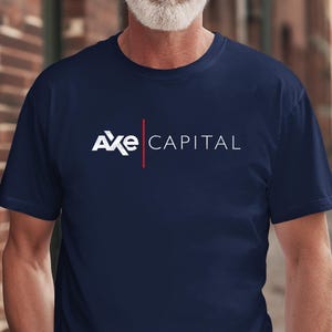 Peut inclure: T-shirt bleu marine avec le texte blanc "Axe CAPITAL" et une ligne verticale rouge. Le t-shirt à manches courtes est fait d'une matière douce. Le design est centré sur la poitrine.
