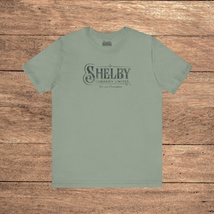 Sage green Bella+Canvas 3001 t-shirt featuring a vintage Shelby Company Limited logo from Peaky Blinders.